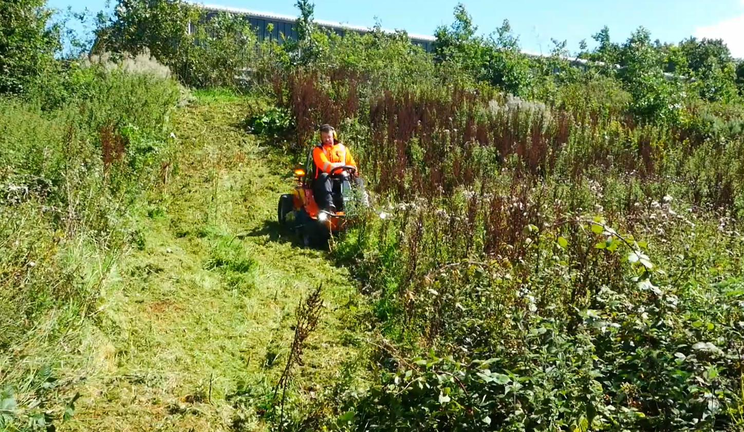 The 4x4 flail mower working a steep grassy hillside
